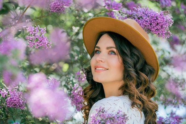 Portret pięknej młodej kobiety w kwitnącym bzu parku.