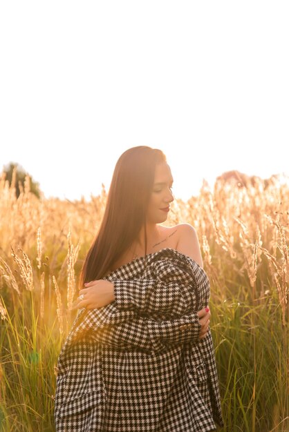 Portret pięknej młodej kobiety w polu pszenicy o zachodzie słońca