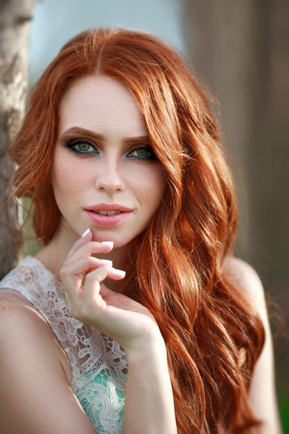 portret pięknej młodej kobiety z rudymi włosami z makijażem i fryzurą