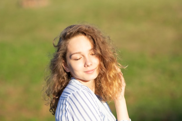 Portret pięknej młodej kobiety z zamkniętymi oczami w letnim parku