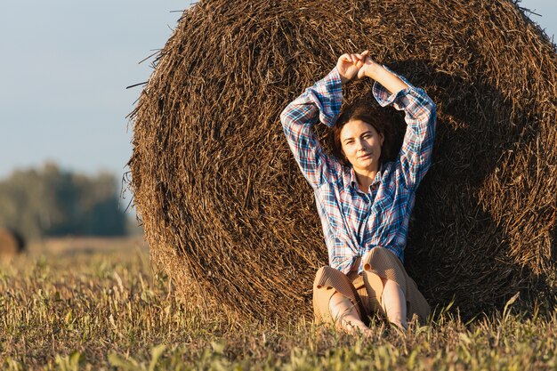 Portret pięknej młodej modelki w beżowych spodniach i koszuli w kratę