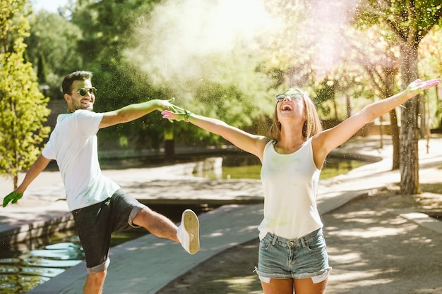 Portret pięknej młodej pary grającej w parku na festiwalu kolorów holi.