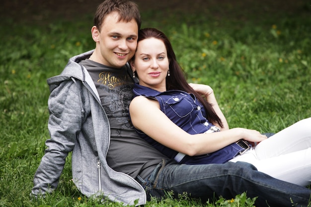 Portret pięknej młodej pary siedzi na ziemi w relaksującym parku