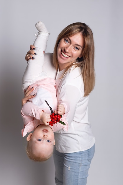 Portret pięknej młodej uśmiechniętej matki z dzieckiem w ramionach