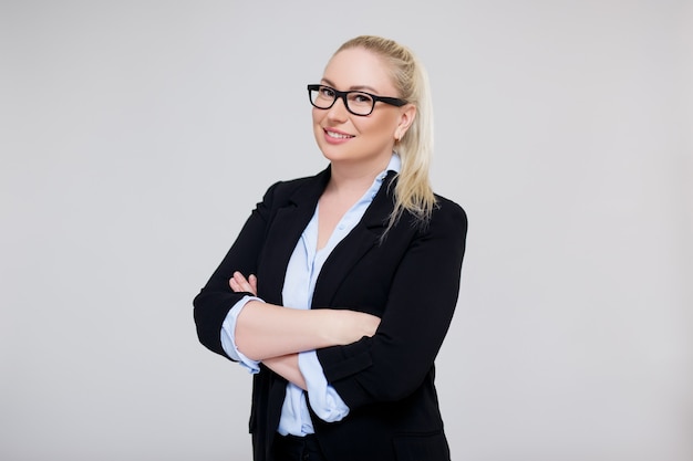 Portret pięknej plus size blond kobieta biznesu lub nauczyciela pozowanie na szarym tle z kopią przestrzeni