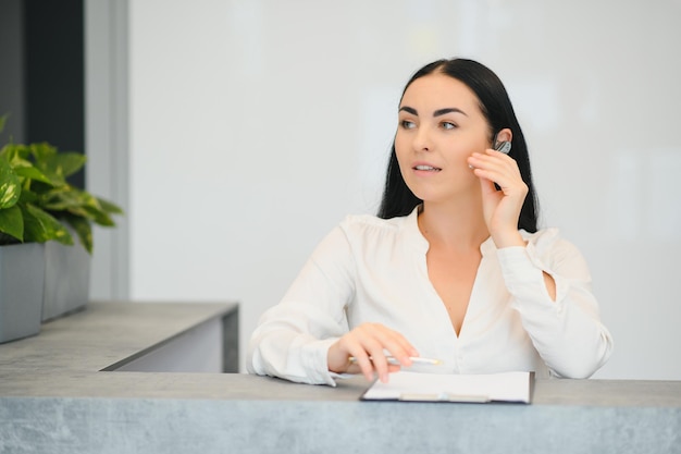 Zdjęcie portret pięknej recepcjonistki w pobliżu lady w hotelu?