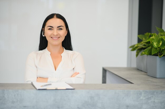 Zdjęcie portret pięknej recepcjonistki w pobliżu lady w hotelu?