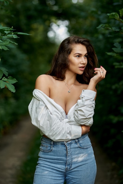 Portret pięknej seksownej dziewczyny w rozpiętej białej koszuli w lesie Pojęcie ludzi