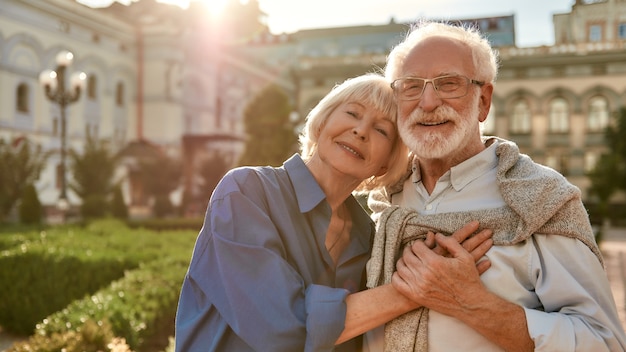 Portret pięknej szczęśliwej pary seniorów, która łączy się ze sobą i trzyma się za ręce, stojąc w