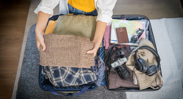 Portret piękności azjatycka podróżniczka kobieta pakowanie przygotować rzeczy i ubrania w walizce bagaż podróży bagaż na wakacje letnie weekend wycieczka wycieczka wakacyjna wycieczka w domu