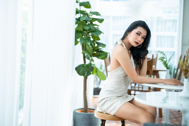 Portret piękny azjatycki freelancer Ludzie sukcesu biznes kobieta modelka w letniej białej sukience bez rękawów i kawa w filiżance w kawiarni