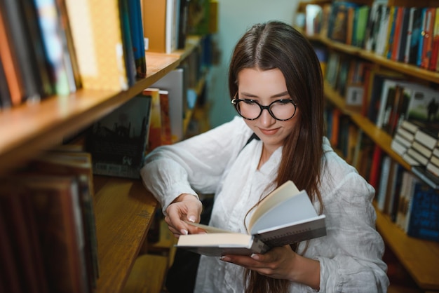 Portret piękny uczeń w bibliotece