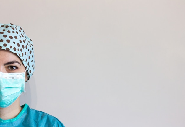 Zdjęcie portret pielęgniarki z higieniczną twarz chirurgiczne maski medyczne i suknia.