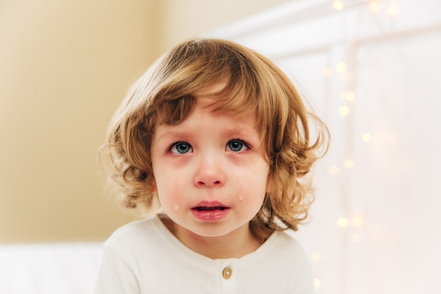Portret Płaczącej Dziewczynki. Małe Słodkie Dziewczyny Crying.indoor.curly Włosy I Niebieskie Oczy.
