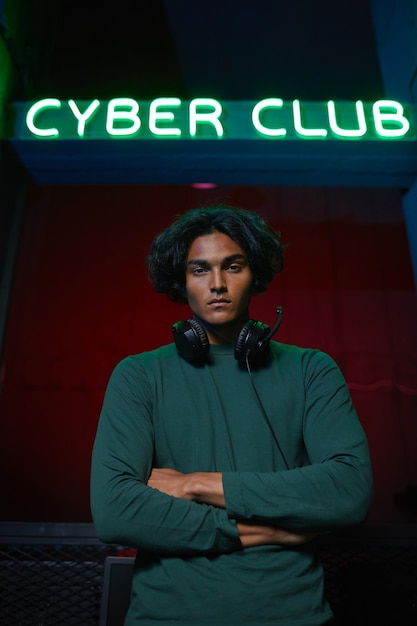 Portret Poważnego Gracza Stojącego Z Rękami Skrzyżowanymi I Patrząc Na Kamery W Klubie Cyber