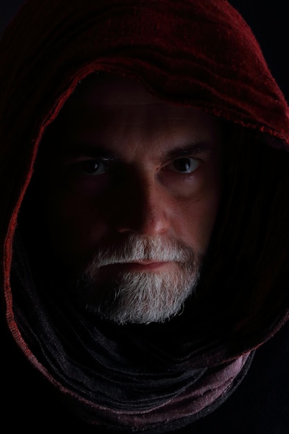 Portret poważnego mężczyzny w chustce na czarnym tle