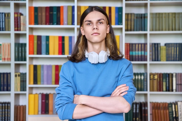 Portret poważnego studenta patrzącego na kamerę w bibliotece