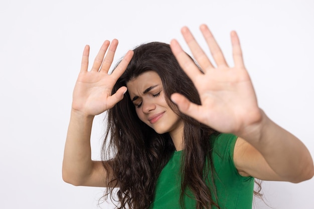 Portret poważnej młodej kobiety pokazującej gest przerwy z dłonią na białym tle
