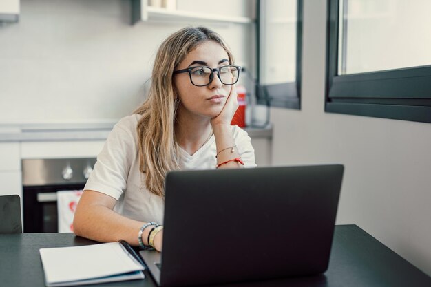 Portret poważnej tysiąclecia białej studentki siedzącej przy biurku w domu studiuje online na laptopie Myślliwa młoda atrakcyjna kobieta używa komputera bierze kursy na odległość lub szkolenia Koncepcja edukacji xA