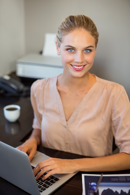 Portret pracuje na laptopie uśmiechnięty bizneswoman