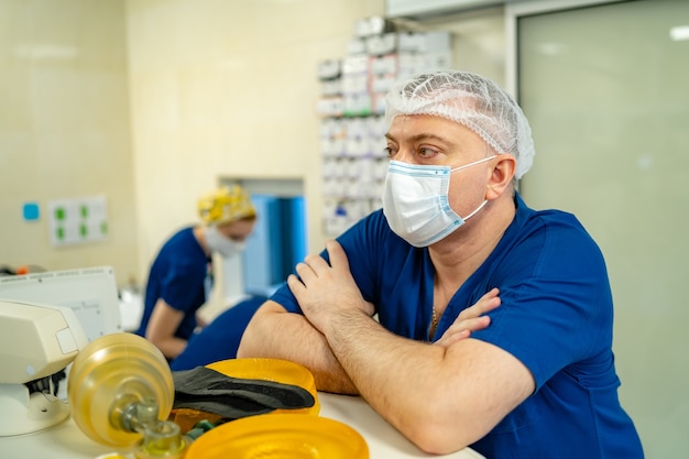 Portret Profesjonalnego Chirurga. Lekarz Nosi Maskę. Lekarz Siedzący W Pobliżu Profesjonalnego Sprzętu.