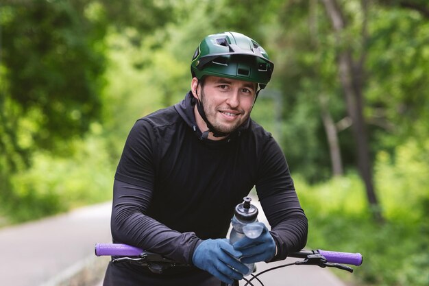 Portret przystojnego cyklisty po odpoczynku i wodzie pitnej