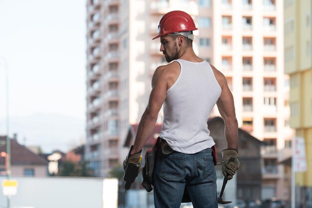 Portret przystojnego męskiego inżyniera architekta w czerwonym kasku