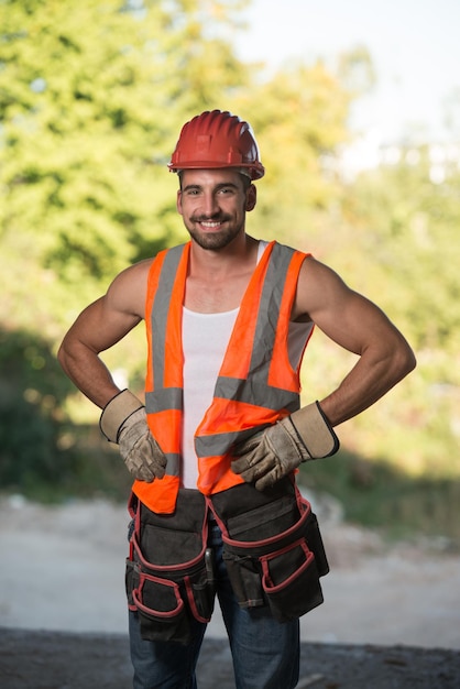 Portret przystojnego męskiego inżyniera architekta w czerwonym kasku