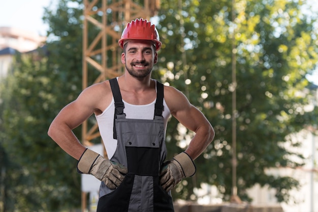 Portret przystojnego męskiego inżyniera architekta w czerwonym kasku