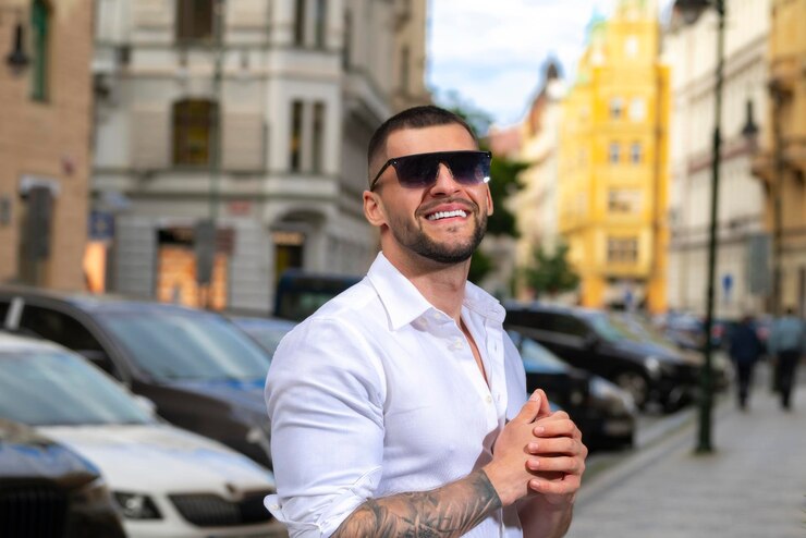 Zdjęcie portret przystojniaka hipster model chłopak na świeżym powietrzu młody modny mężczyzna w okularach przeciwsłonecznych w mieście pewny siebie model mężczyzna wyglądający dumnie atrakcyjny mężczyzna na ulicy europejskiej elegancki chłopak