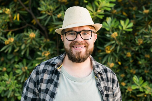 Portret przystojniaka nad zielonym krzewem na zewnątrz miejsca do kopiowania i reklamy
