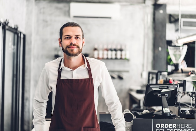 Portret Przystojny Brodaty Mężczyzna Właściciela Małej Firmy Barista Uśmiecha Się Za Ladą W Kawiarni