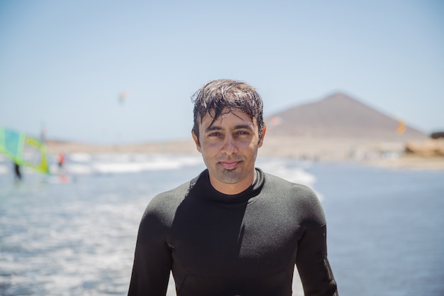 Portret przystojny Indianin, surfer na plaży patrząc na kamery, sporty ekstremalne i rekreacja - skupienie się na twarzy.