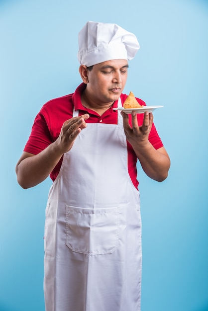 Portret przystojny indyjski mężczyzna kucharz pozuje podczas wykonywania czynności
