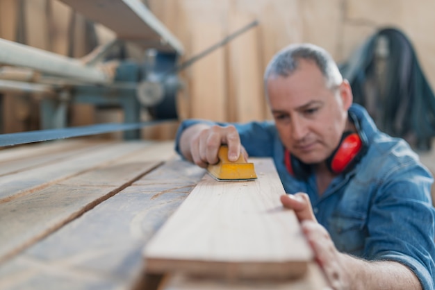 Portret przystojny precyzyjny cabinetmaker podczas pracy w warsztacie.