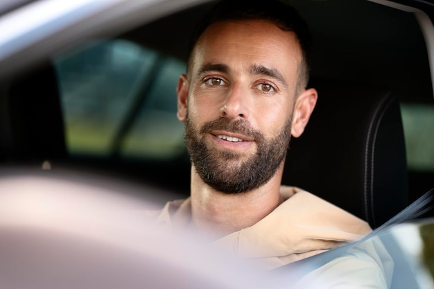 Portret przystojny uśmiechający się Łacińskiej jazdy samochodem patrząc na kamery. Koncepcja transportu