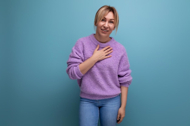 Portret radosnej uśmiechniętej blond młodej kobiety w przypadkowym spojrzeniu z miłym sercem i silną