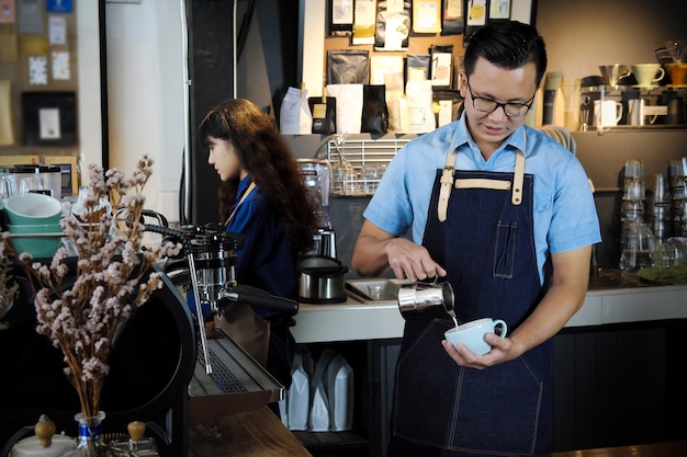 Portret robi latte lub cappucino kawie w sklep z kawą barista