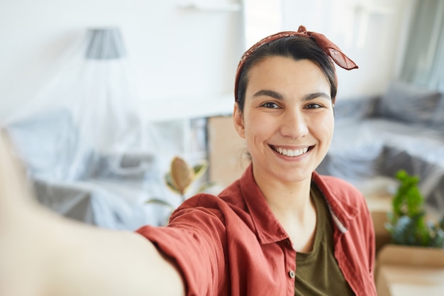 Zdjęcie portret robi selfie portret szczęśliwa młoda kobieta w domu