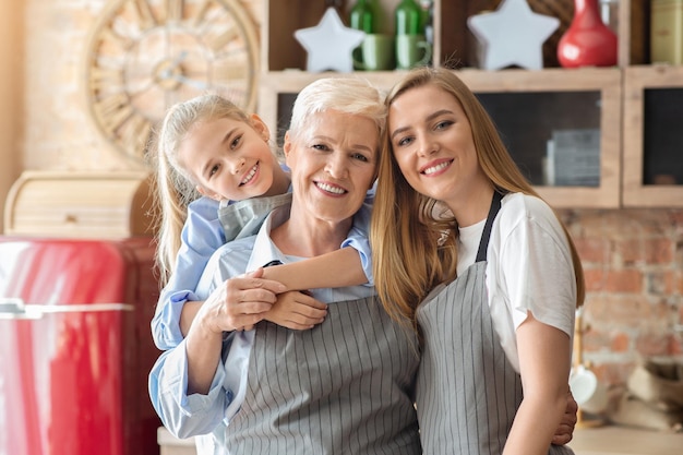 Portret Rodzinny Na Tle Kuchni, Mała Dziewczynka I Jej Mama Przytulają Wesołą Babcię, Kopia Przestrzeń