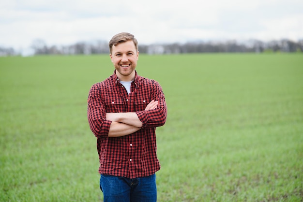 Portret rolnika stojącego na polu pszenicy
