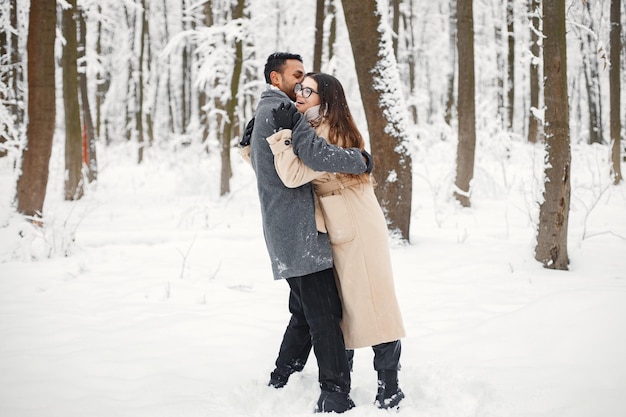 Portret romantycznej pary spędzającej razem czas w zimowym lesie