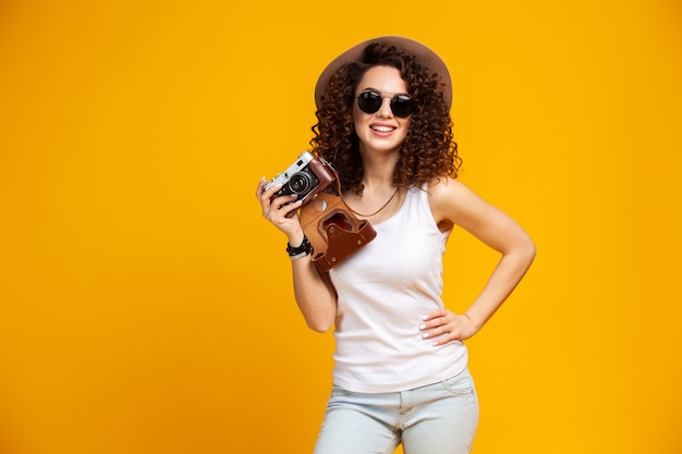 Portret Roześmiana Młoda Kobieta W Okularach Robienia Zdjęć Na Aparat Fotograficzny Retro Starodawny Na Białym Tle Na Jasny żółty