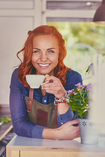Portret rude kobiece barista w małej kawiarni.