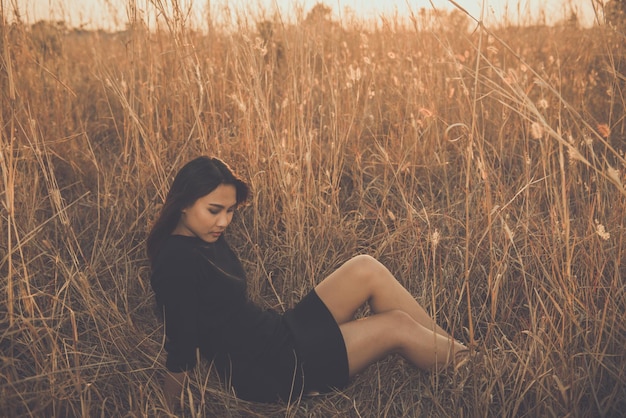 Portret samotnej kobiety samotnej w polu Styl vintage z filtremzłamane serce z koncepcji miłosnej smutnej dziewczyny w stylu vintage o zachodzie słońca