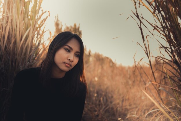 Portret samotnej kobiety samotnej w polu Styl vintage z filtremzłamane serce z koncepcji miłosnej smutnej dziewczyny w stylu vintage o zachodzie słońca