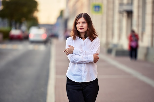 Portret samotnej młodej kobiety na cichej ulicy miasta