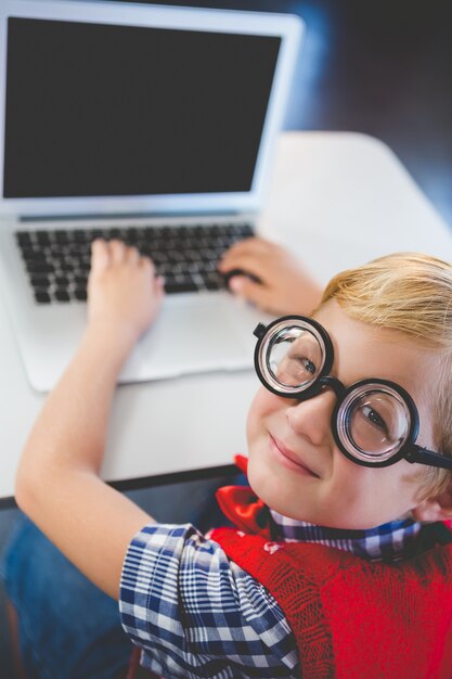 Zdjęcie portret schoolkid używa laptop w sala lekcyjnej