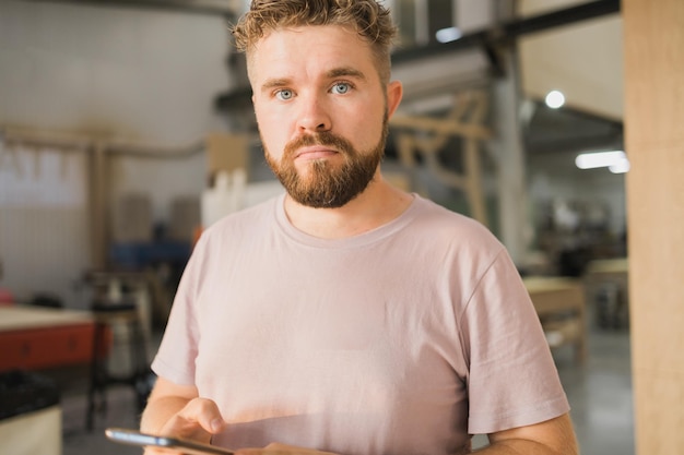 Portret sfrustrowanego zdezorientowanego faceta, młodego, smutnego, zdenerwowanego, przystojnego mężczyzny, który patrzy na kamerę, otrzymuje negatywne wiadomości na smartfonie