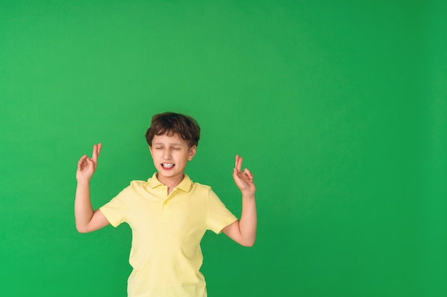 Portret siedmioletniego chłopca, kciuki i życzący powodzenia